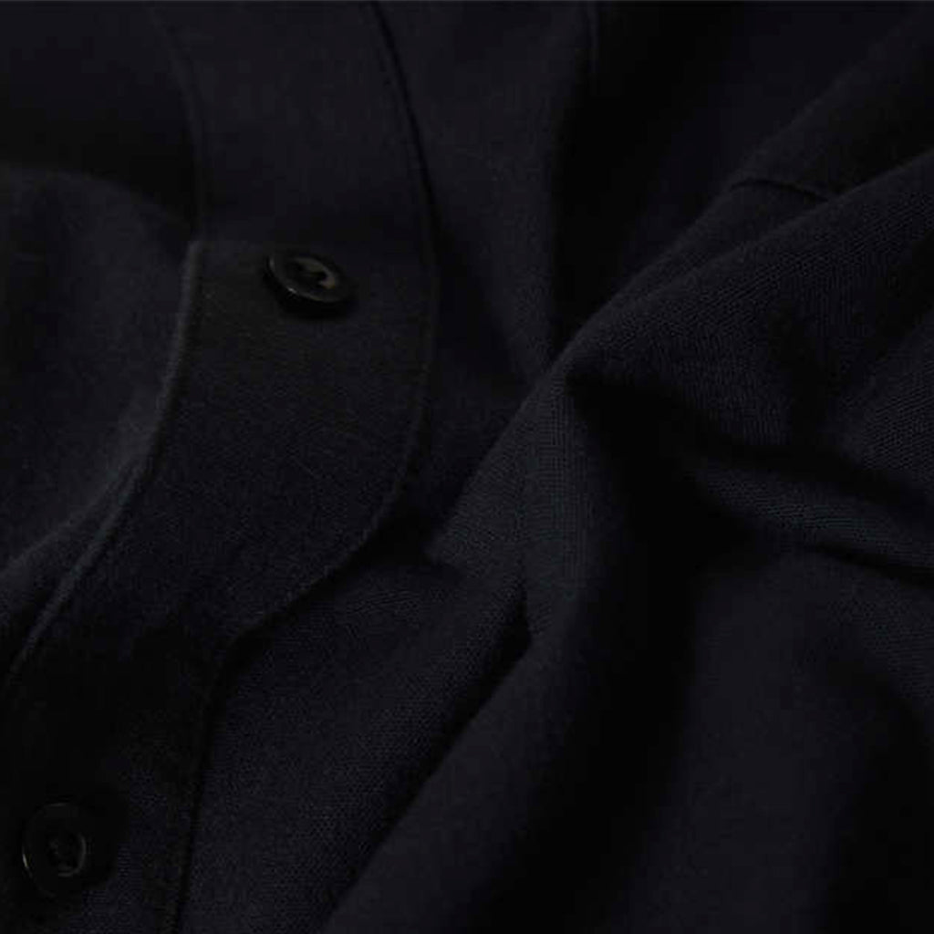 Close-up of a dark coat with buttons on a black background