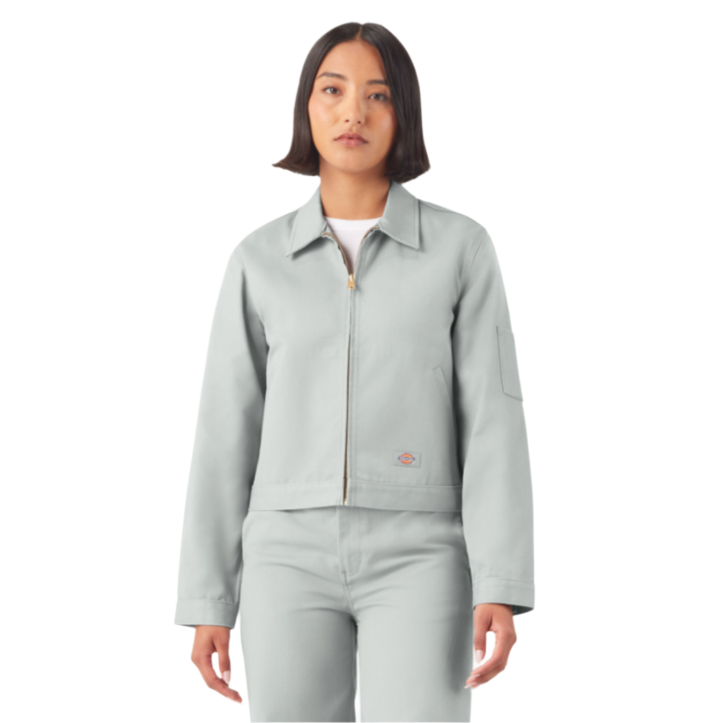 A woman wearing a cropped grey Eisenhower jacket with long sleeves, angled front welt pockets, and an adjustable waistband.