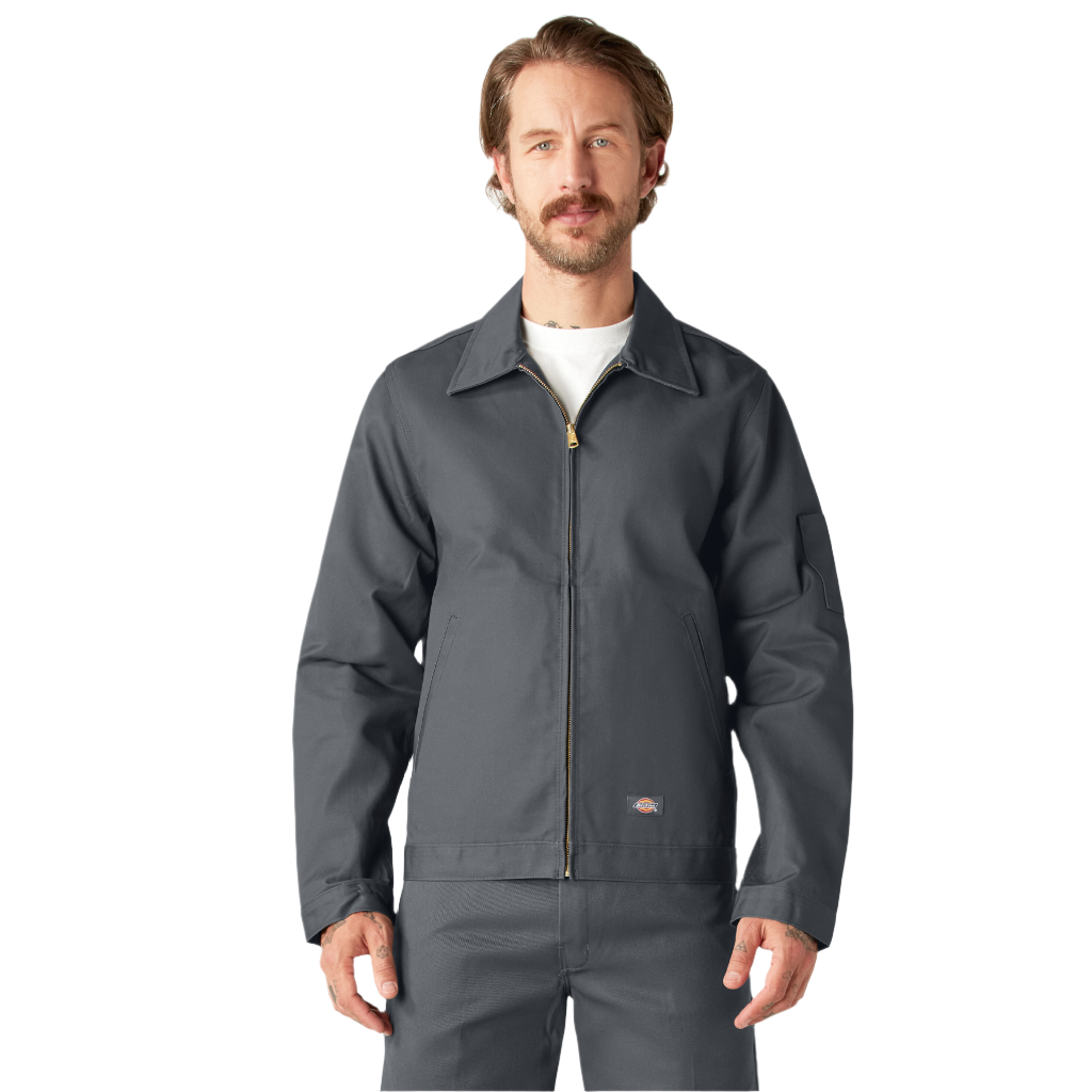 A man wearing a charcoal-colored Dickies Men's Unlined Eisenhower Jacket with a brass zipper and multiple front pockets.