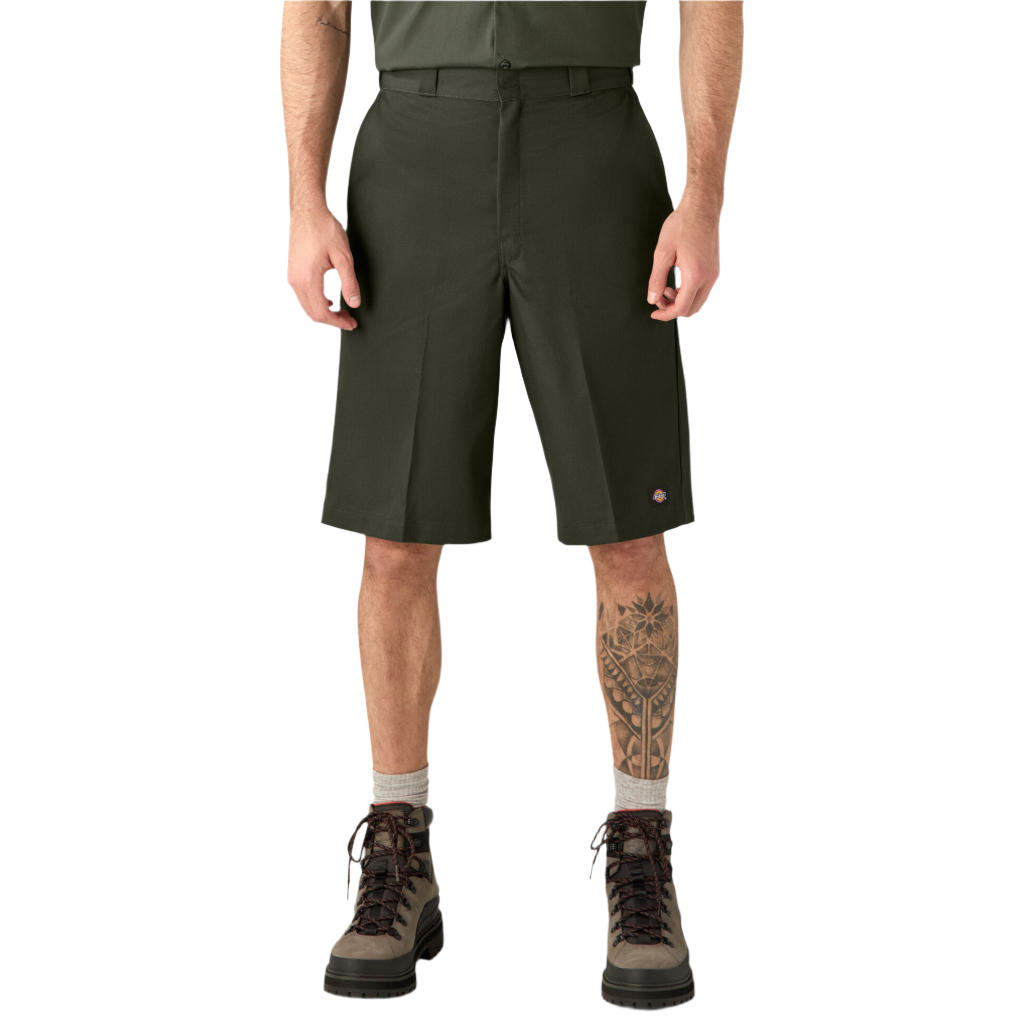 A person standing wearing olive green Dickies work shorts with a flat front design and multiple pockets, paired with a belt and boots.