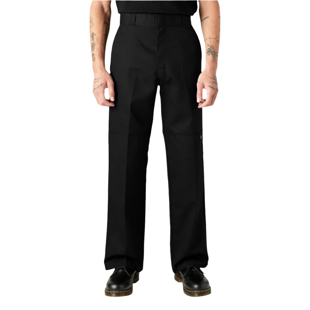 A person standing, wearing loose fit double knee work pants in black with a straight leg cut and high-rise waistband.