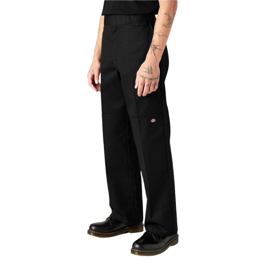 A person standing, wearing loose fit double knee work pants in black with a straight leg cut and high-rise waistband.