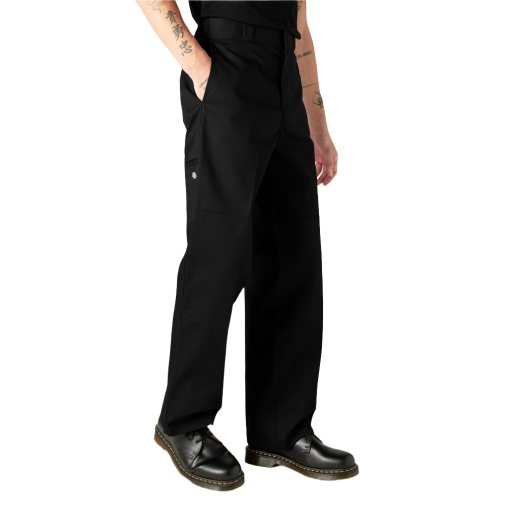 A person standing, wearing loose fit double knee work pants in black with a straight leg cut and high-rise waistband.