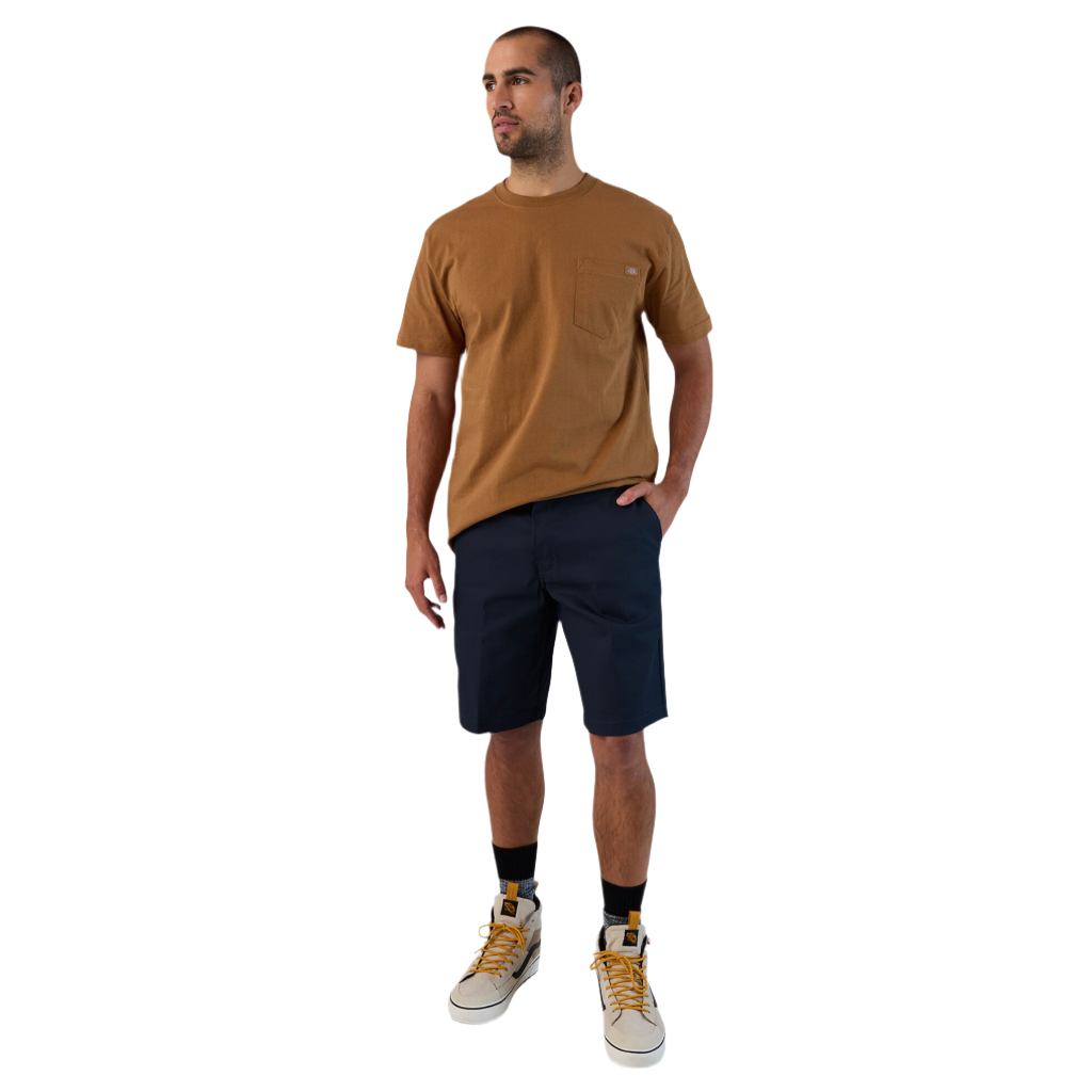 A man wearing a brown t-shirt and dark navy work shorts, standing against a white background.