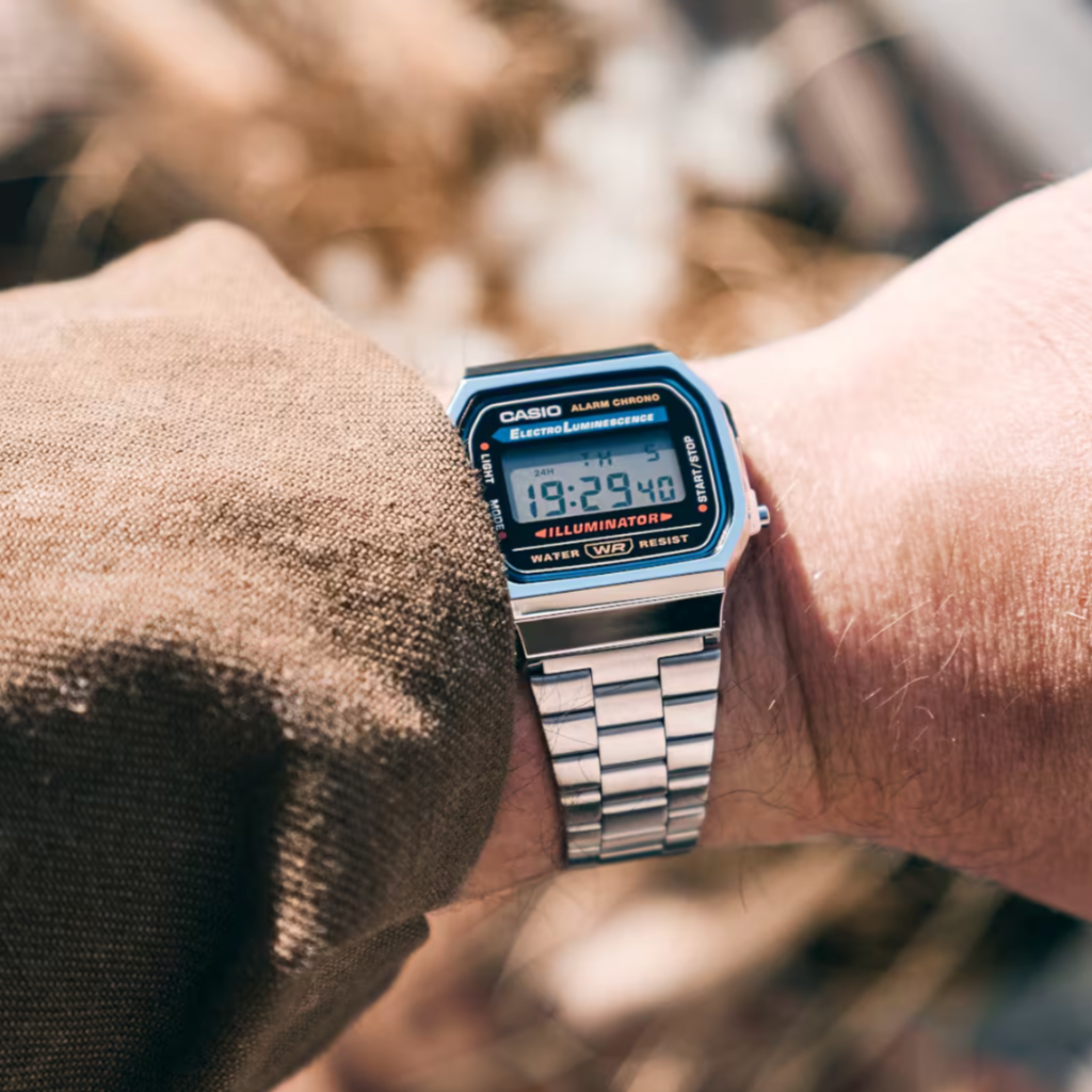 Digital watch on a wrist with a blurred natural background