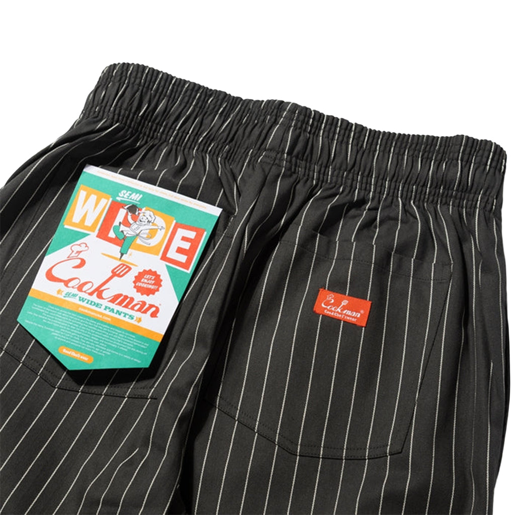 Black pinstripe shorts with a colorful label on a white background