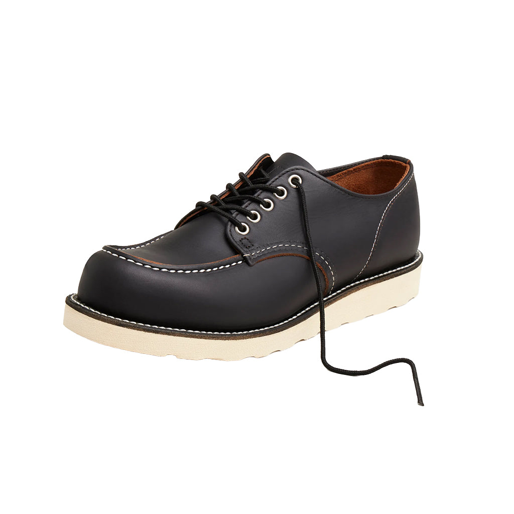 Black leather shoe with white sole on a white background