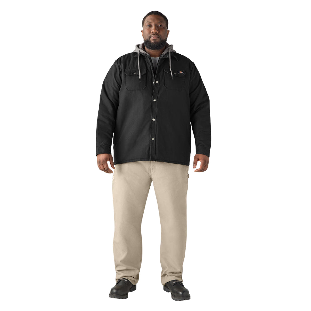 Man wearing a black jacket and beige pants on a white background