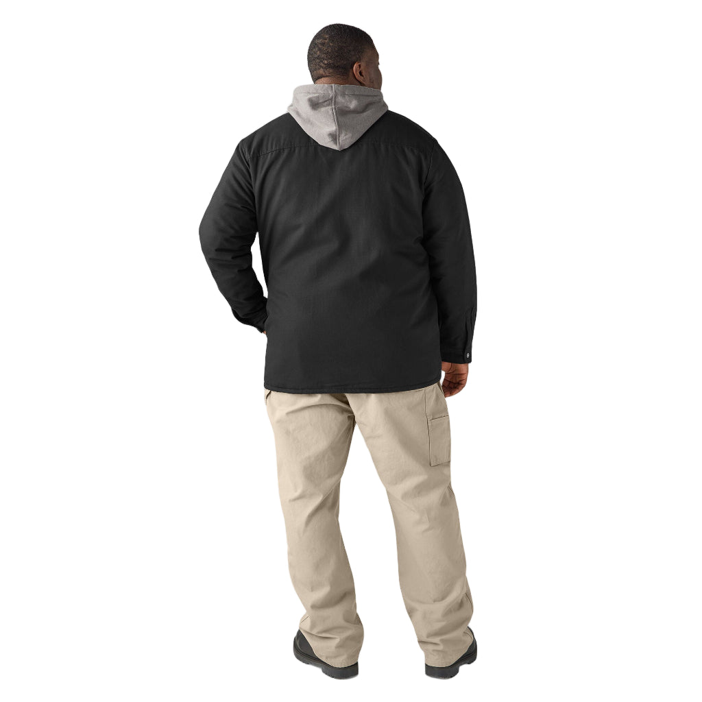 Man wearing a black jacket with a gray hood and beige pants on a white background