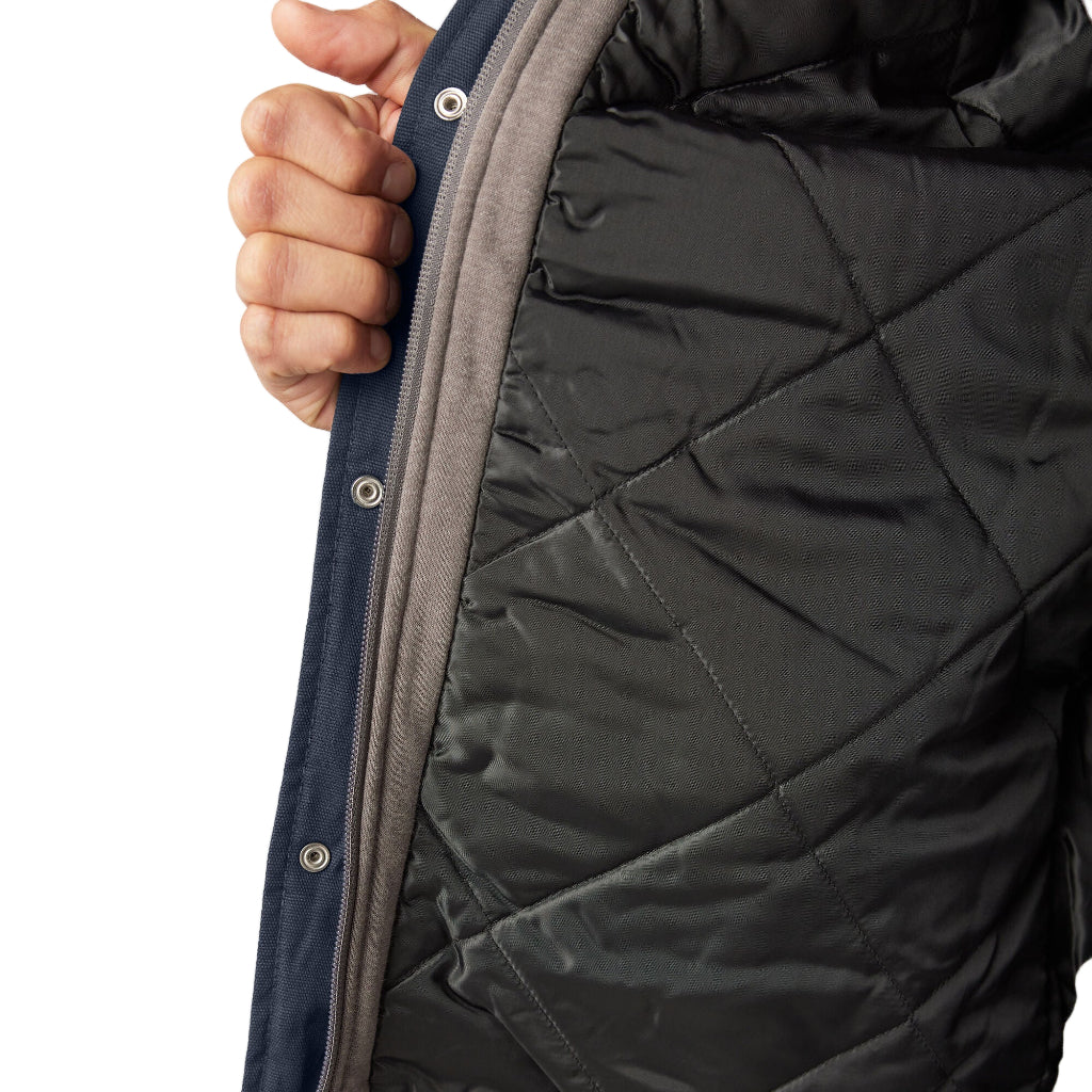 Close-up of a person wearing a black quilted jacket with a white background