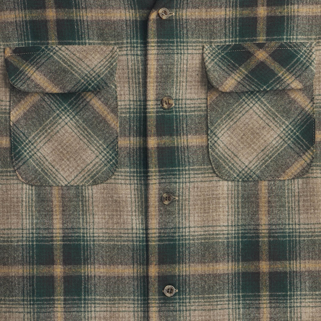 Close-up of a green and brown plaid shirt with button details.