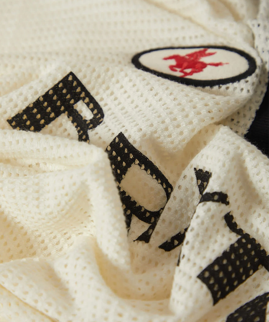 Close-up of a textured fabric with embroidered text and logo