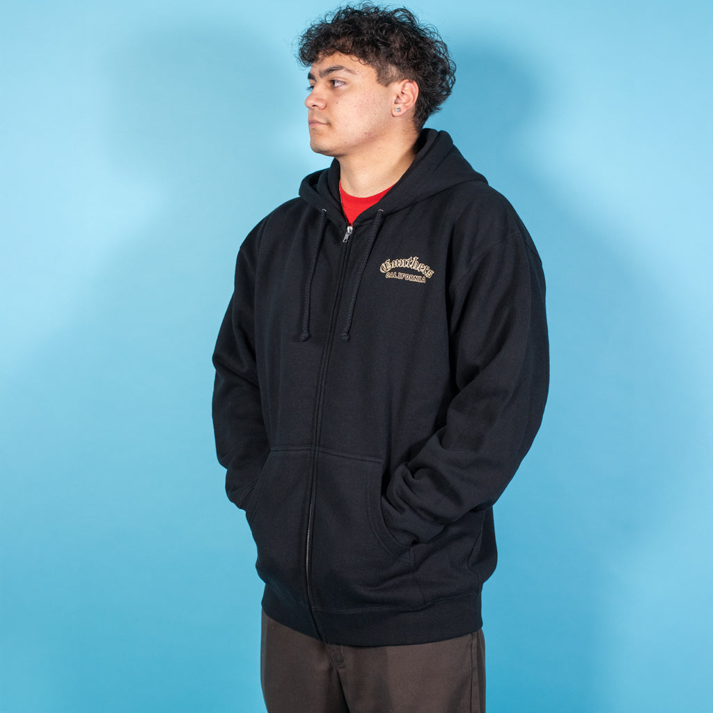 Person wearing a black hoodie with a logo on a blue background