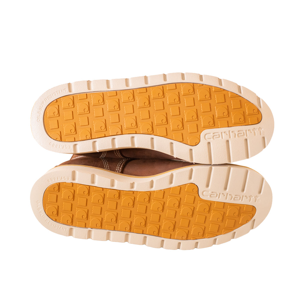 Close-up of a pair of shoes with orange soles on a white background