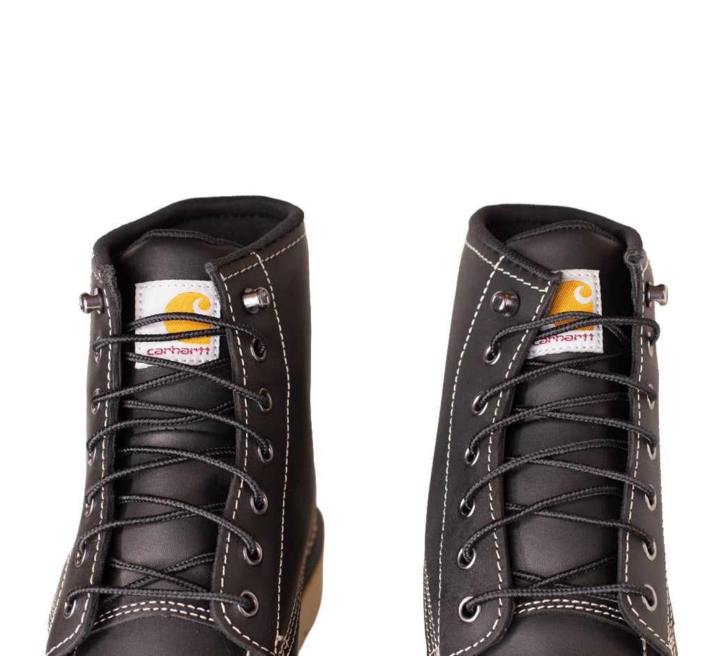 Pair of black leather boots with Carhartt logo on a white background