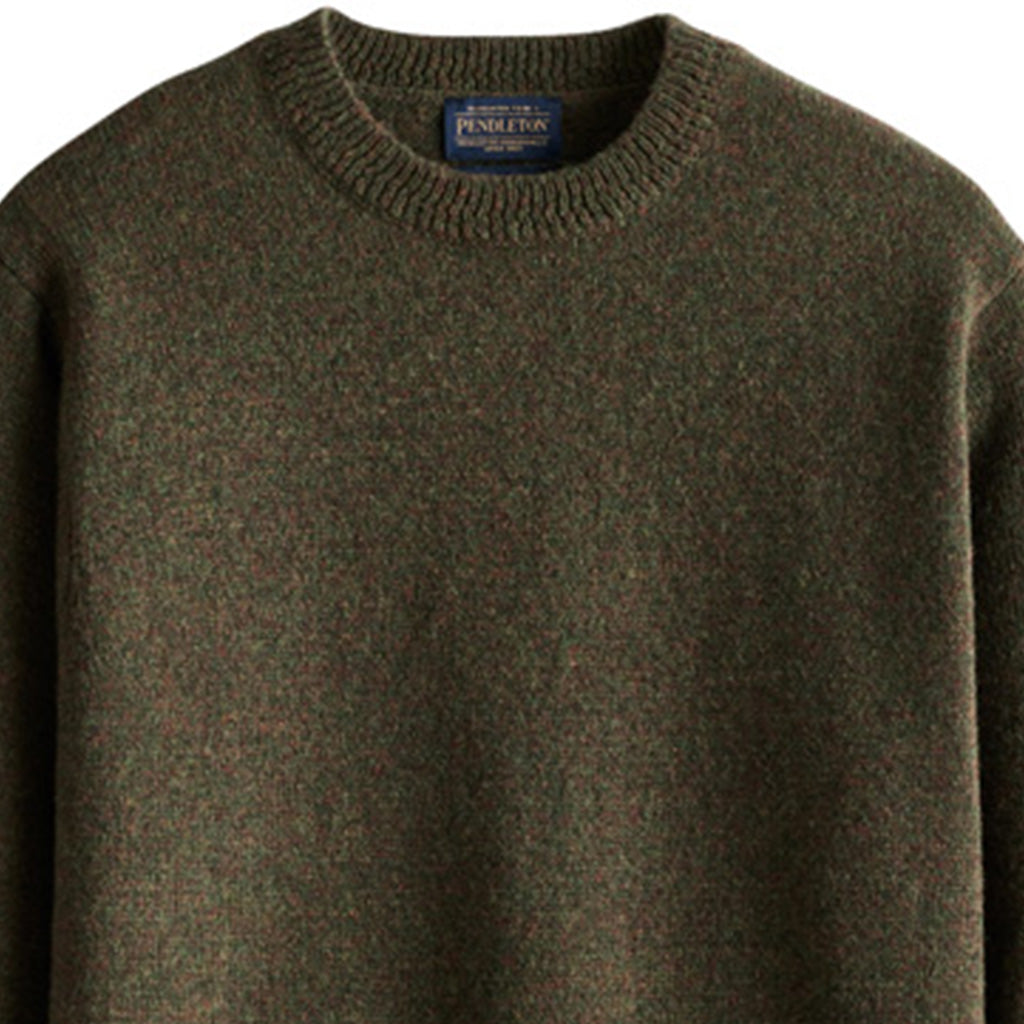 Green sweater with a brand label on a white background