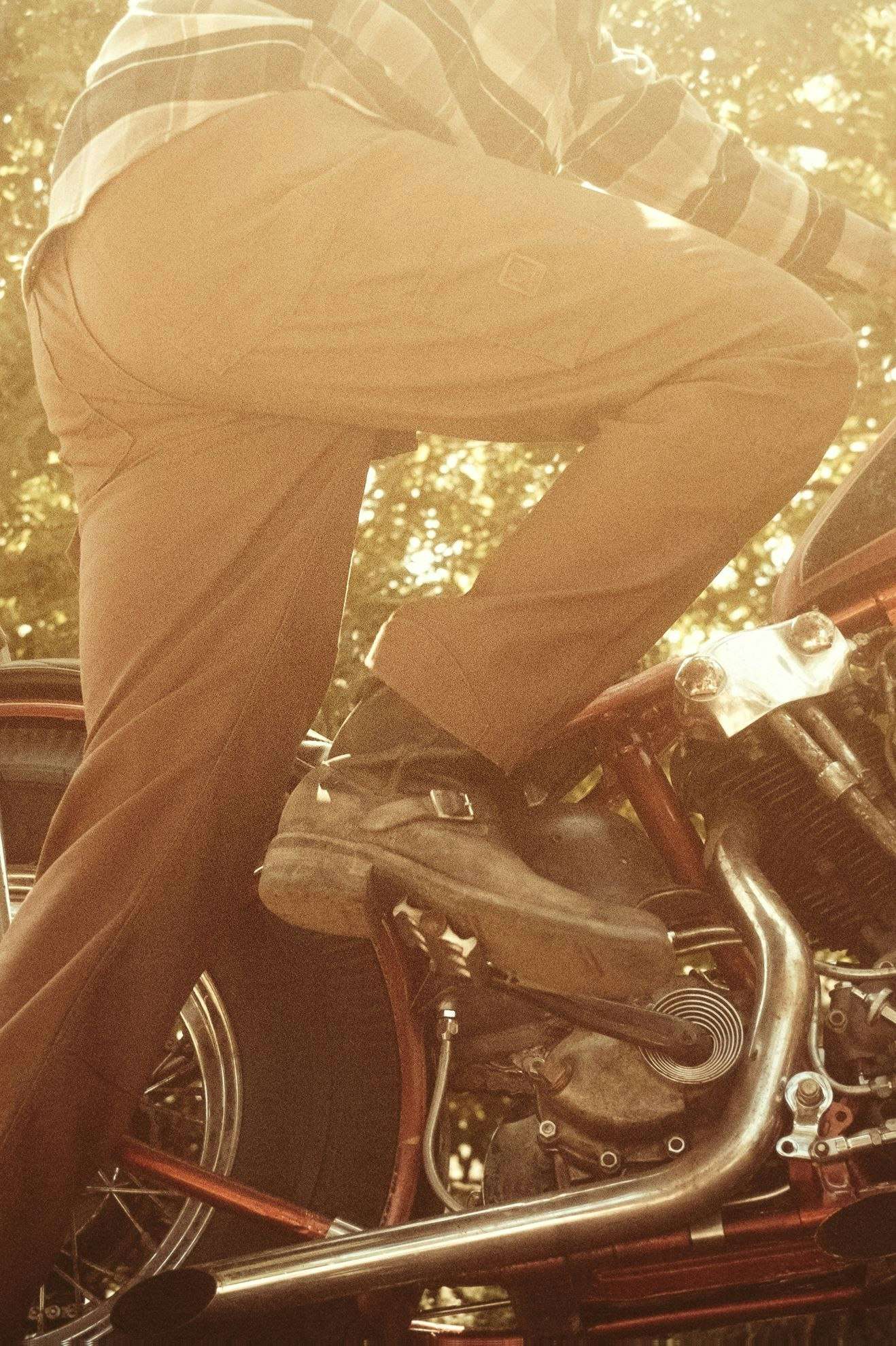 Person sitting on a motorcycle with a blurred natural background