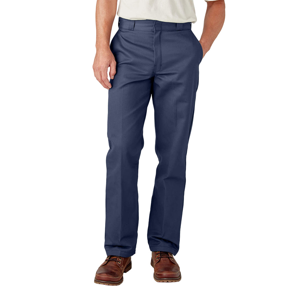 A person standing with hands in pockets wearing navy Dickies men's original 874 work pants.