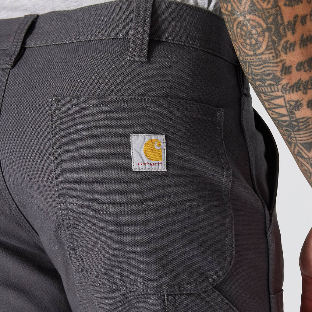 Close-up of a pocket on dark pants with a visible brand logo.