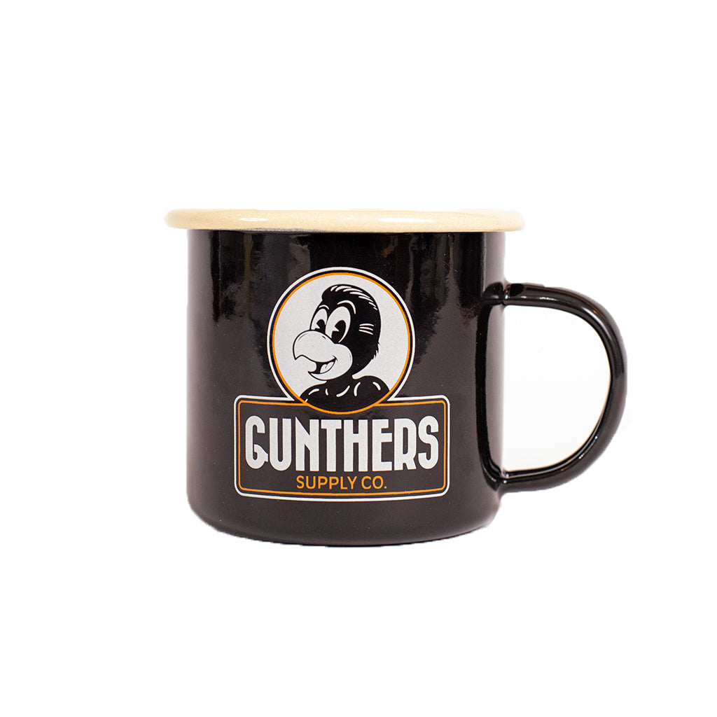 A black enamel mug with a parrot design and 'Gunthers Supply Co' text on the front.