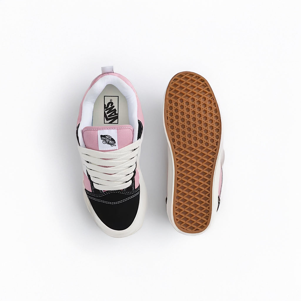 Pink and black sneaker with white sole on a light gray background