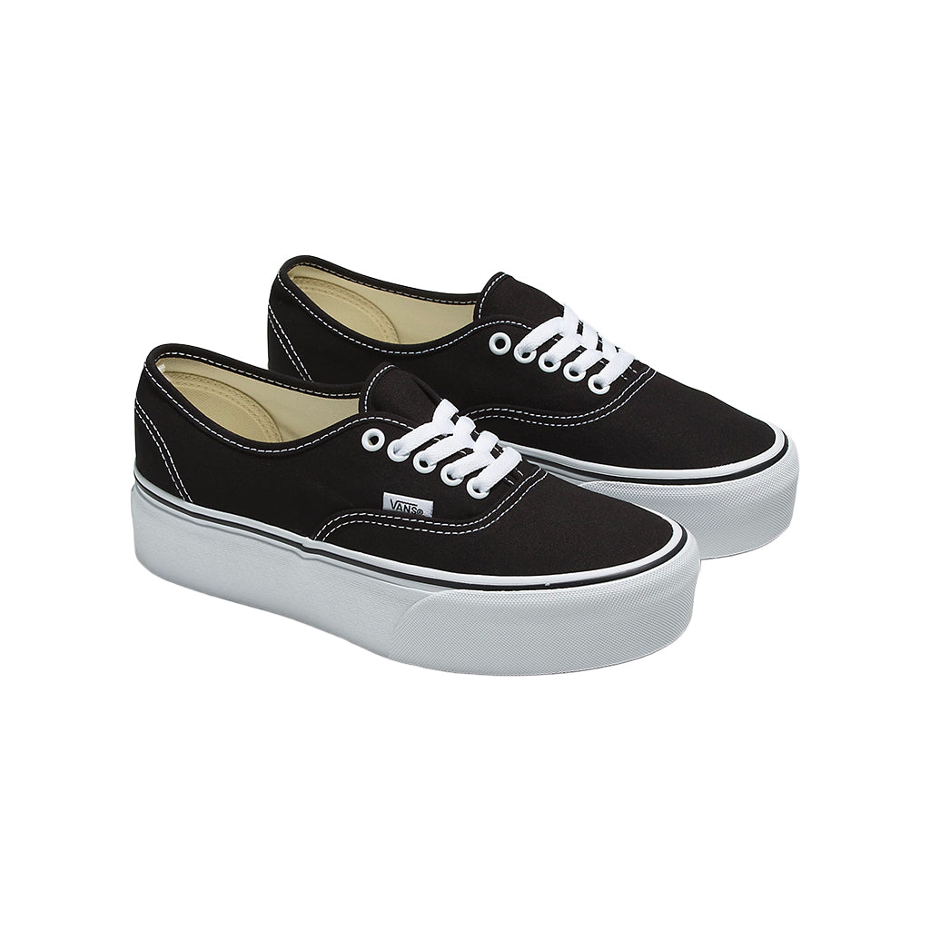 Pair of black sneakers with white laces on a white background