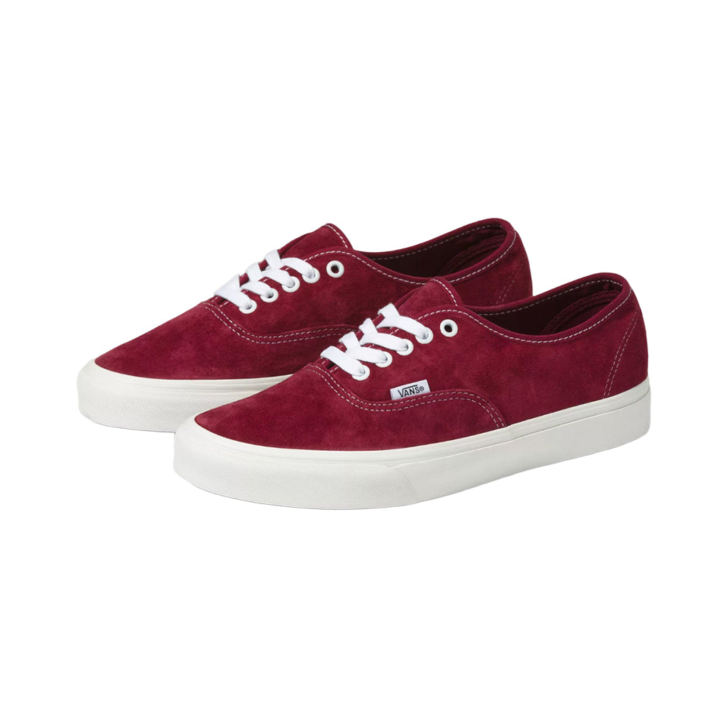 A pair of red Vans Authentic Pig Suede sneakers with white laces and a rubber waffle outsole.