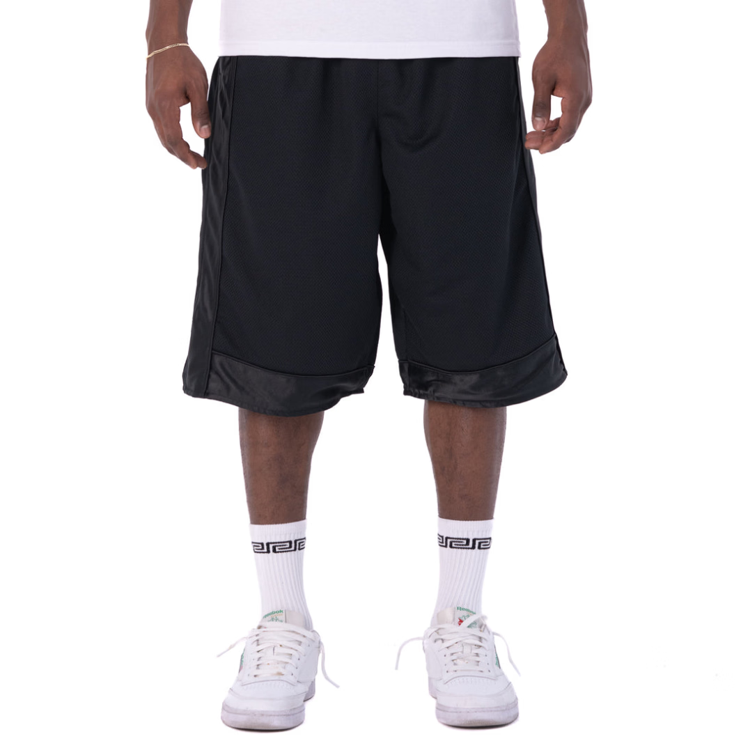 Person wearing black shorts, white socks, and white sneakers on a white background