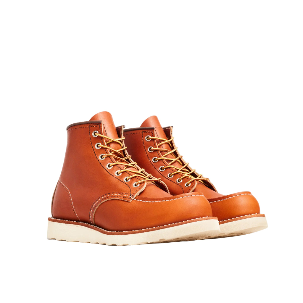 Pair of brown leather boots with white soles on a white background