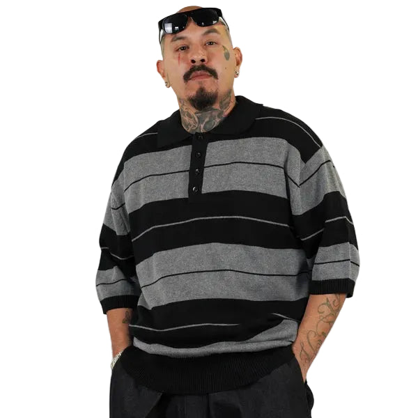 Man wearing a black and gray striped sweater against a white background