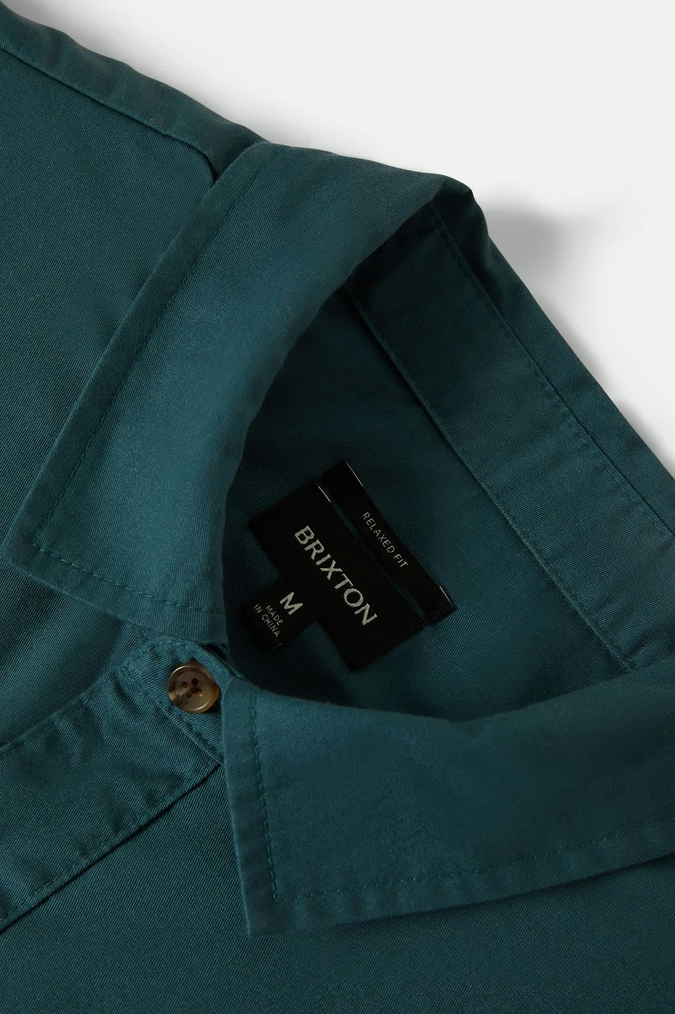 Teal shirt with a Brixton label on a white background