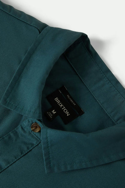 Teal shirt with a Brixton label on a white background