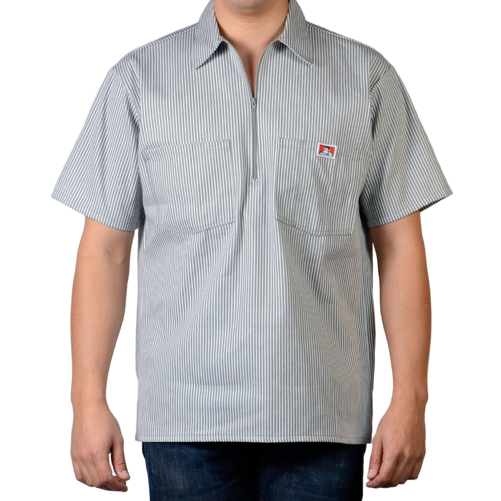 Person wearing a short-sleeve striped shirt with a logo on a plain background