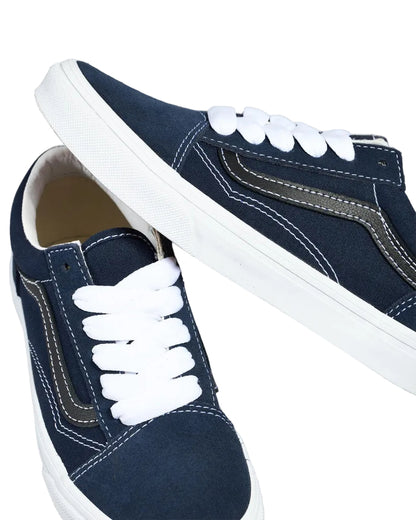 Pair of navy blue sneakers with white laces on a white background