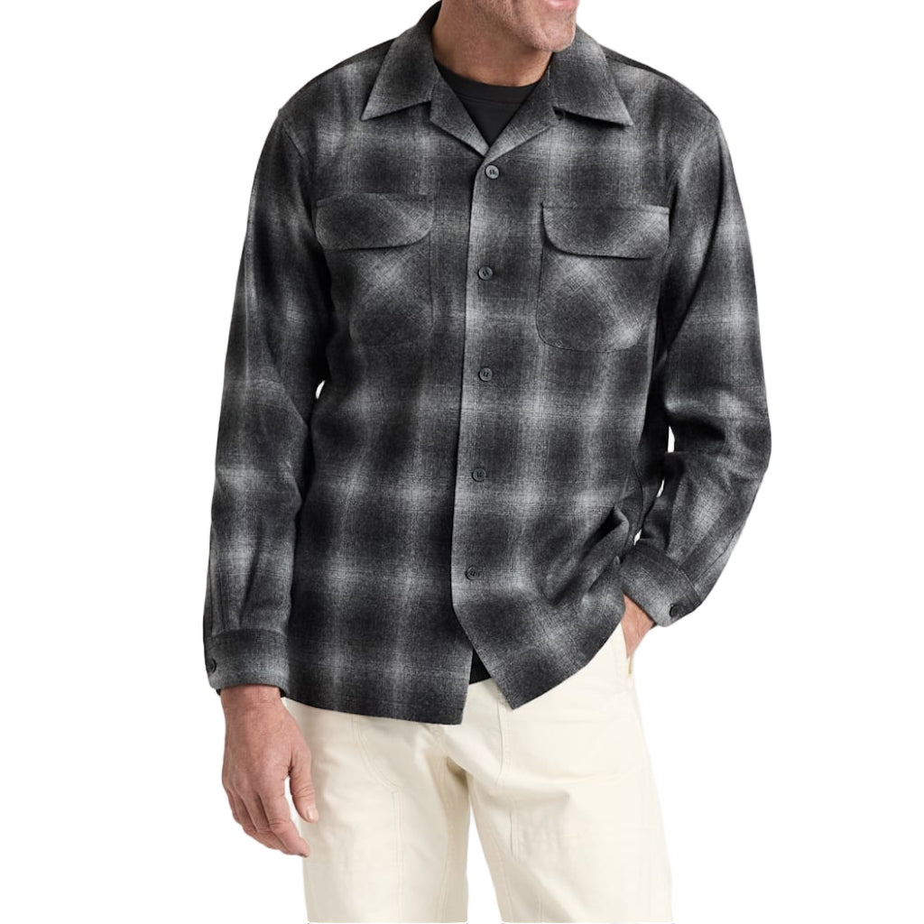 Man wearing a gray plaid shirt against a white background