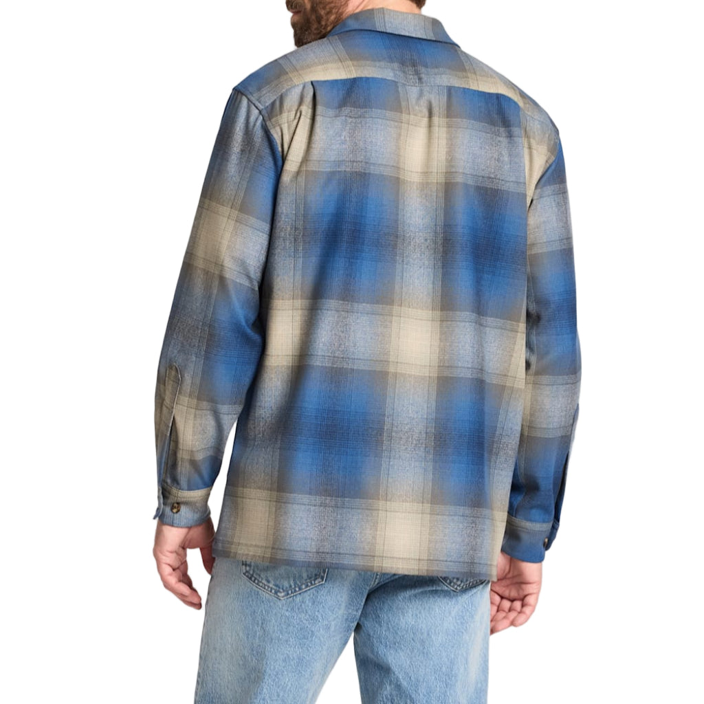 Man wearing a blue and beige plaid shirt on a white background