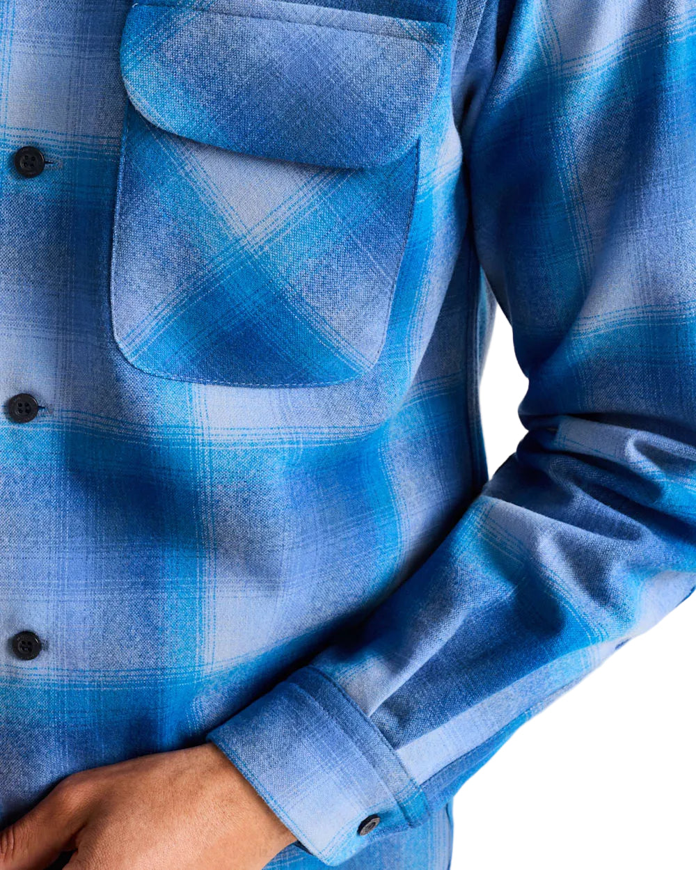 Close-up of a blue plaid shirt with a pocket on a white background