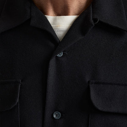 Close-up of a dark shirt with a button detail