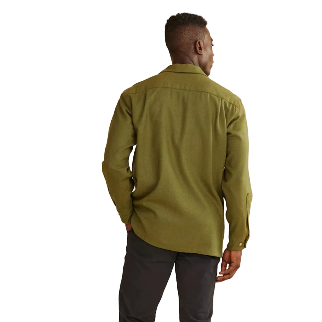 Man wearing a green shirt and dark pants on a white background