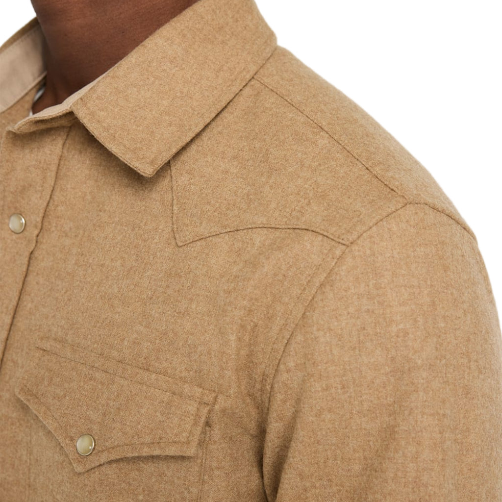 Close-up of a beige shirt with collar and button details on a white background