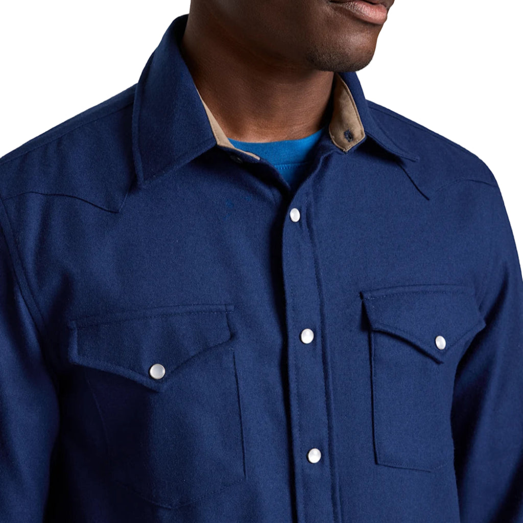 Navy blue shirt with white buttons worn by a person on a plain white background