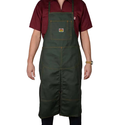 Person wearing a green apron over a red shirt on a white background