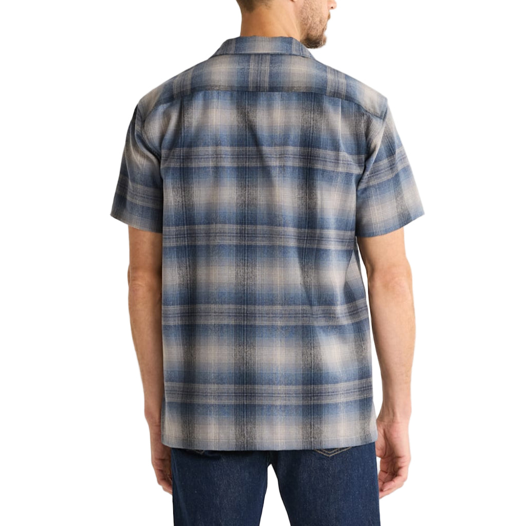 Man wearing a blue and gray plaid short-sleeve shirt on a white background