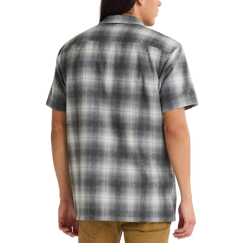 Person wearing a plaid shirt with a white background