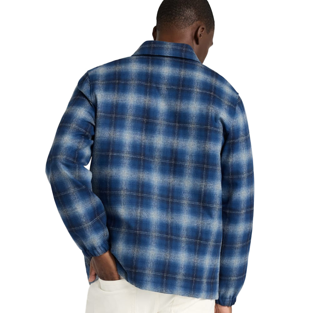 Man wearing a blue plaid shirt against a white background