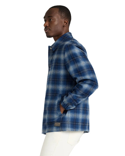 Man wearing a blue plaid shirt on a white background