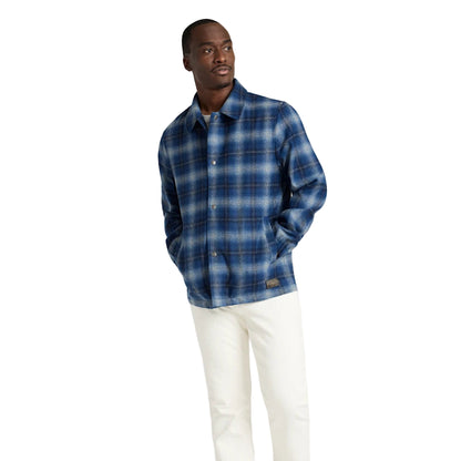 Man wearing a blue plaid shirt against a white background