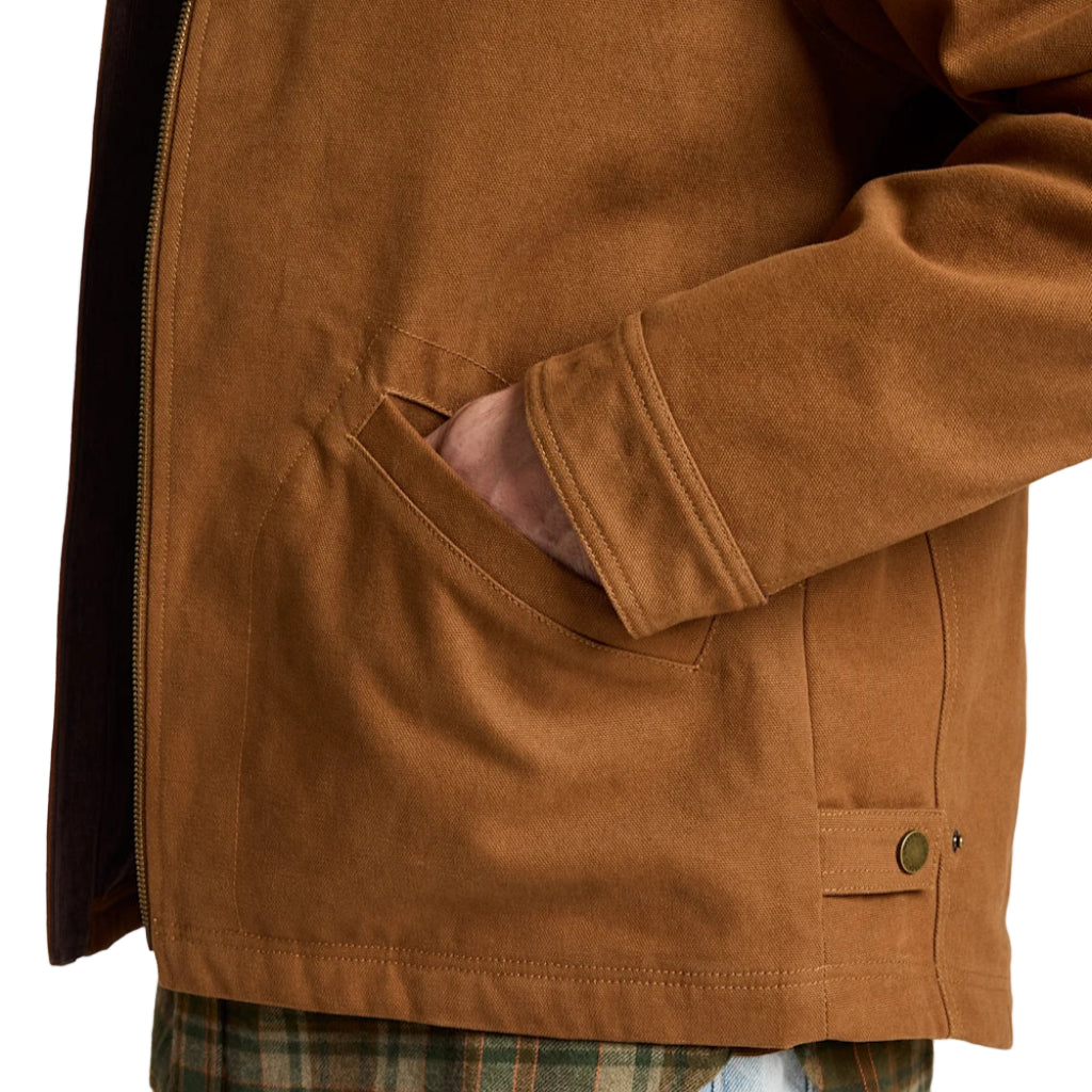 Brown jacket worn over a plaid shirt and jeans on a white background