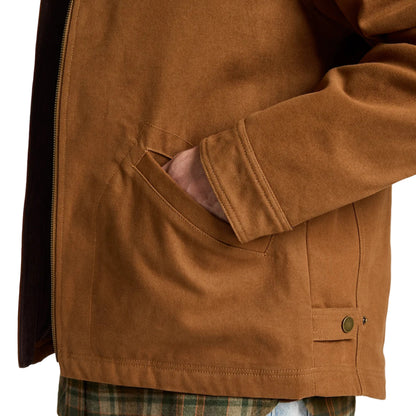 Brown jacket worn over a plaid shirt and jeans on a white background