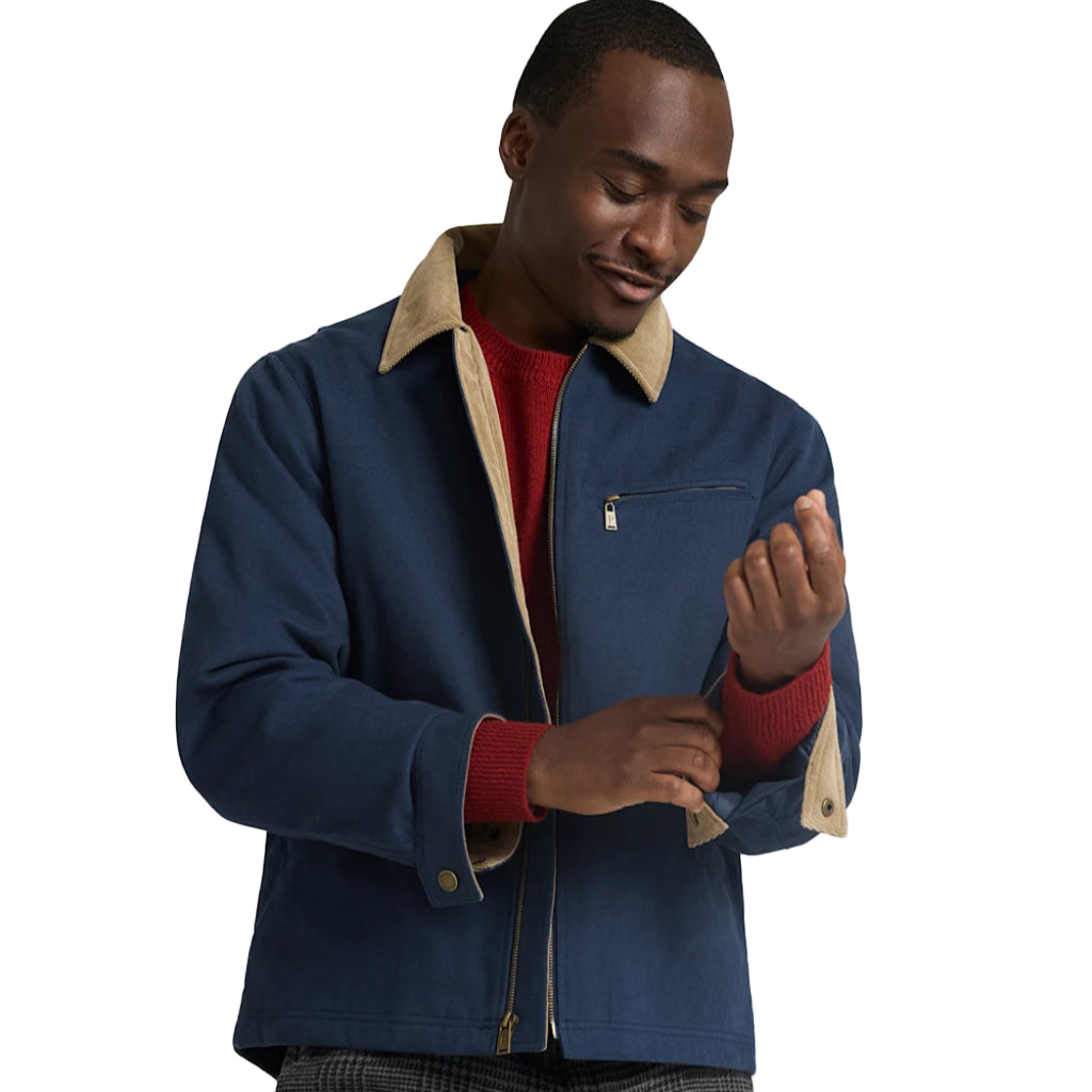 Man wearing a blue jacket with beige collar and red cuffs on a white background